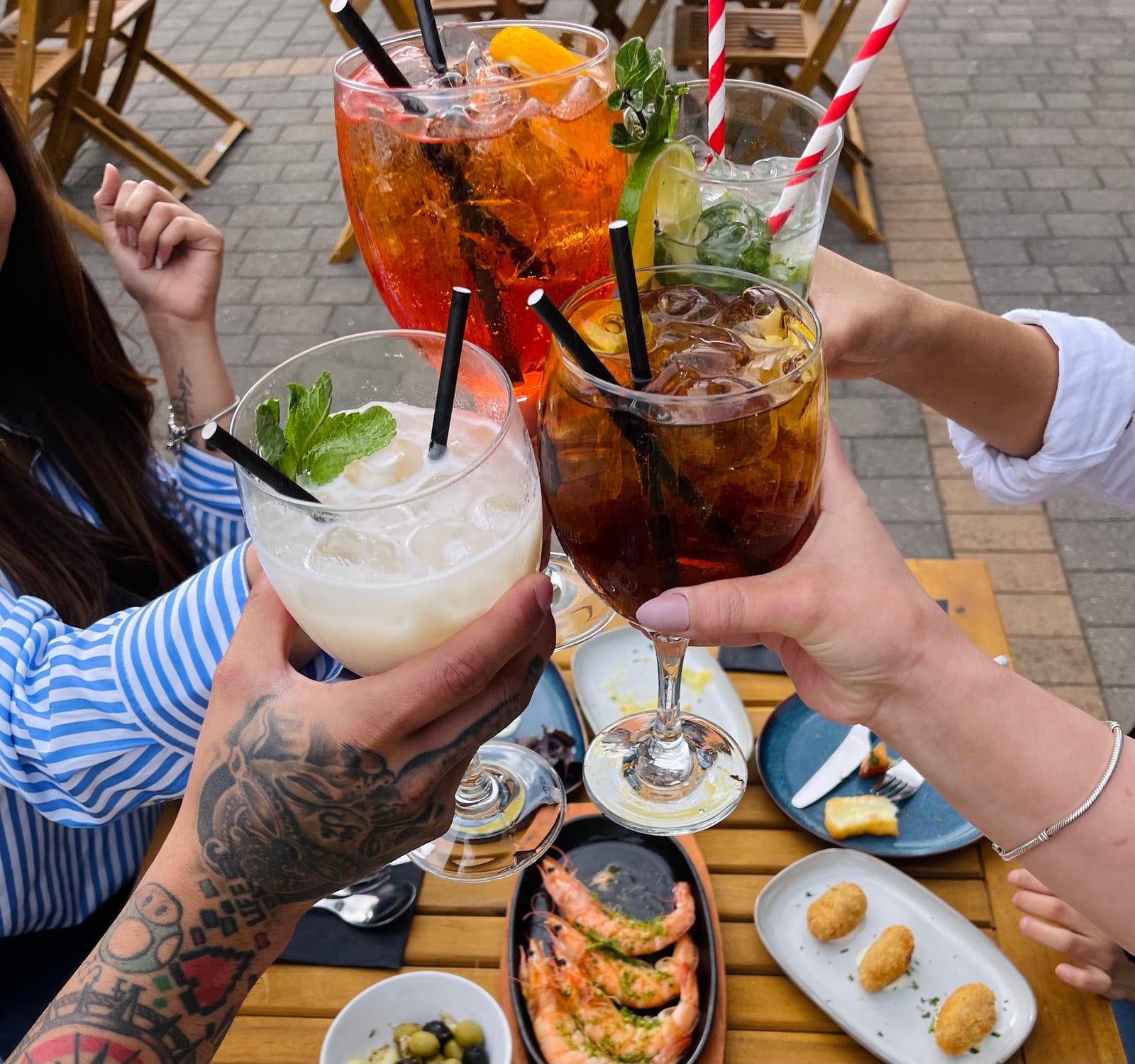 Glasses raised over tapas on the La Fonda terrace